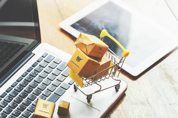 Boxes in a trolley on a laptop keyboard. Ideas about online shop