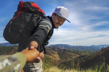 Genç adam tırmanışa yardım ediyor..