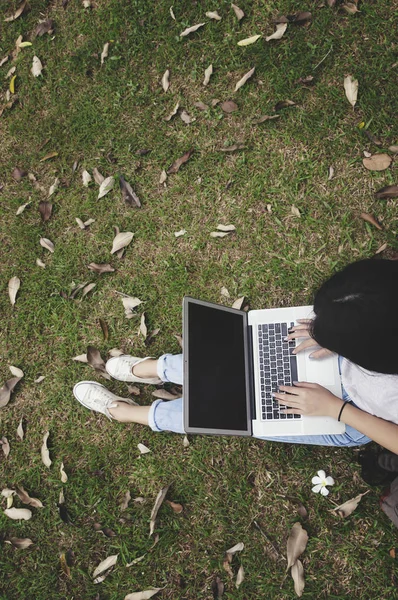 Vista superior de una joven mujer sosteniendo un ordenador portátil en su regazo . — Foto de Stock