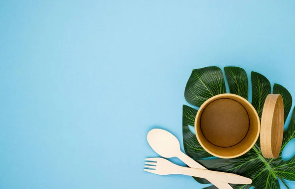 paper coffee cups made of natural eco-friendly material, on tropical leaves on a blue background. the concept of using disposable eco-friendly tableware. the rejection of the plastic