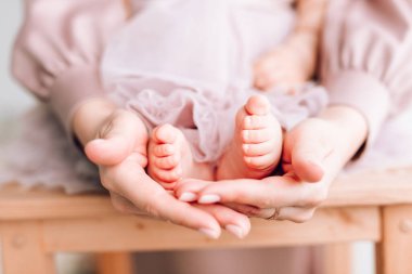 Bebeğin ayakları babanın ellerindeydi. Yeni doğmuş bir bebeğin küçük bacakları erkek ellerinde, yakın plan. Mutlu aile kavramı. Babalar günü.