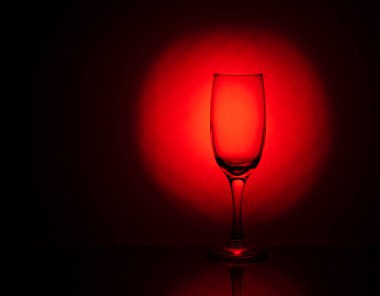 Güzel, kırmızı bir arka planı olan boş bir şarap kadehi. yaratıcı cam çekimler.