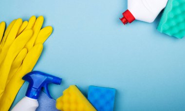 Mutfak, banyo ve diğer odaların çeşitli yüzeylerini temizlemek için hazır. Mavi arkaplanda mesaj ya da logo için boş alan. Temizlik hizmetleri kavramı