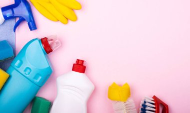 Pastel pembe arka planda ev temizlik seti, yazı için alan, üst görünüm. Odadaki temizliği sürdürme konsepti
