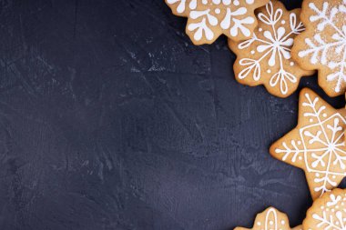 Koyu arkaplanda kar taneleri şeklinde Noel kurabiyeleri, üst manzara. metin için alanı olan yeni yıl arkaplanı