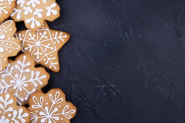 Koyu arkaplanda kar taneleri şeklinde Noel kurabiyeleri, üst manzara. metin için alanı olan yeni yıl arkaplanı