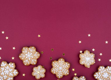 Koyu kırmızı zemin üzerinde Noel kurabiyeleri. Yeni yıl tatili geçmişi