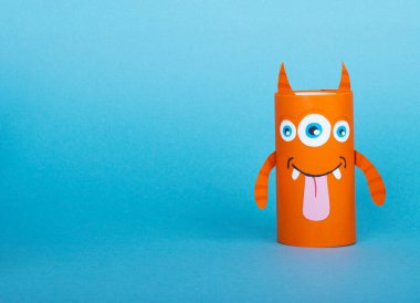 Mavi arka planda tuvalet kağıdından yapılmış renkli canavarlar. El yapımı. tekrar kullanım kavramı