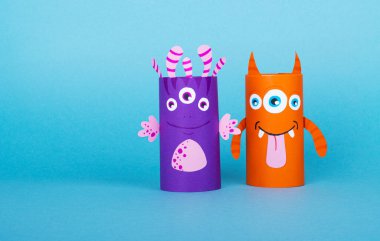 Mavi arka planda tuvalet kağıdından yapılmış renkli canavarlar. El yapımı. tekrar kullanım kavramı