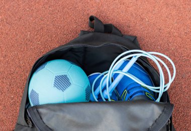Kırmızı arka planda spor aletleri olan çocukların spor çantası. Spor konsepti