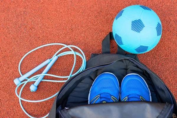 Kırmızı arka planda spor aletleri olan çocukların spor çantası. Spor konsepti