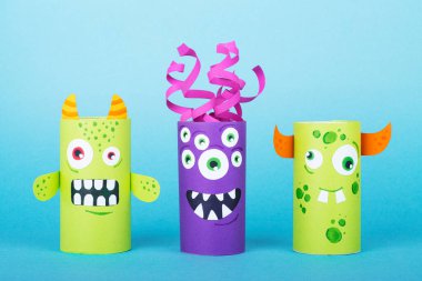 Mavi arka planda kağıt canavarlar. El yapımı konsept, tuvalet tüpünden yaratıcı fikir, geri dönüşüm