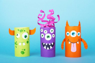 Mavi arka planda kağıt canavarlar. El yapımı konsept, tuvalet tüpünden yaratıcı fikir, geri dönüşüm