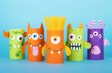 Mavi arka planda kağıt canavarlar. El yapımı konsept, tuvalet tüpünden yaratıcı fikir, geri dönüşüm