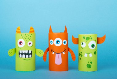 Mavi arka planda kağıt canavarlar. El yapımı konsept, tuvalet tüpünden yaratıcı fikir, geri dönüşüm