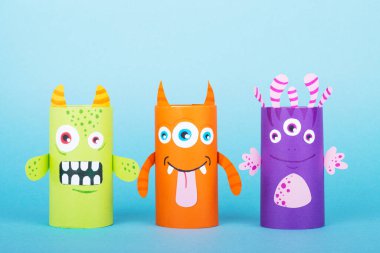 Mavi arka planda kağıt canavarlar. El yapımı konsept, tuvalet tüpünden yaratıcı fikir, geri dönüşüm