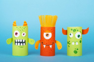 Mavi arka planda kağıt canavarlar. El yapımı konsept, tuvalet tüpünden yaratıcı fikir, geri dönüşüm