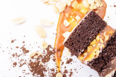 Beyaz arka planda fıstıklı nefis kremalı karamelli tatlı. Çikolata parçaları ve karamel lekeleri