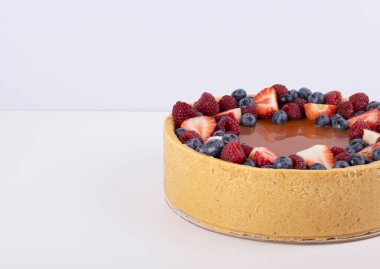 Çilekli kek ve beyaz bir masada taze böğürtlen. Doğal ziyafetler.