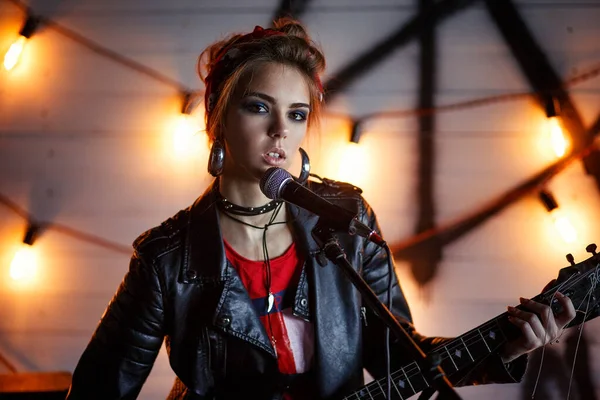 Gitarlı deri ceketli kız.
