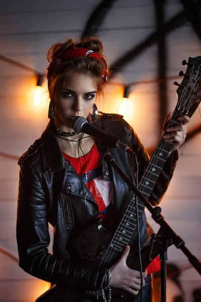 Gitarlı deri ceketli kız.