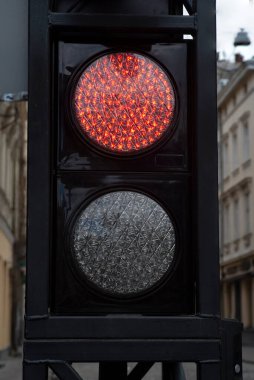 Arka planda eski sarı tramvay olan kırmızı trafik ışığı. 