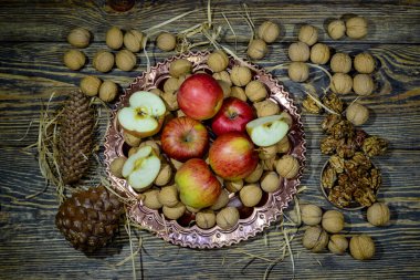 Tahta bir masada ceviz ve kırmızı elmalar. Sağlıklı atıştırmalıklar.