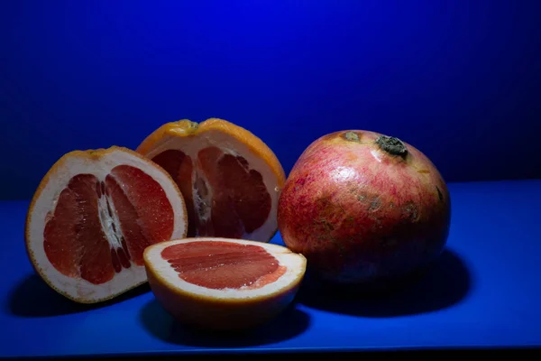 Sliced Ripe Grapefruit Whole Pomegranate Blue Background — Stock Photo, Image