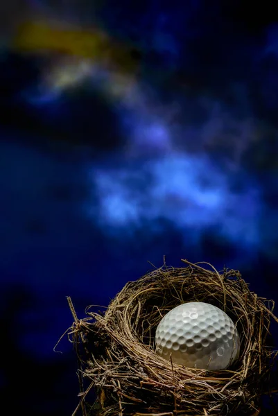 Golf ball ready to play. Dark background.