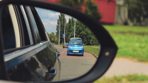 Blaues Auto mit eingeschaltetem Notlicht am Fahrbahnrand angehalten, Rückspiegel eingeschlagen, Verkehr — Stockvideo