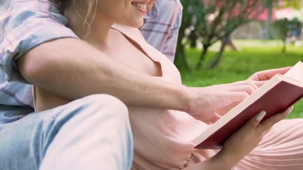 Étudiants universitaires lisant le livre et s'embrassant dans le parc, loisirs romantiques, amour — Video