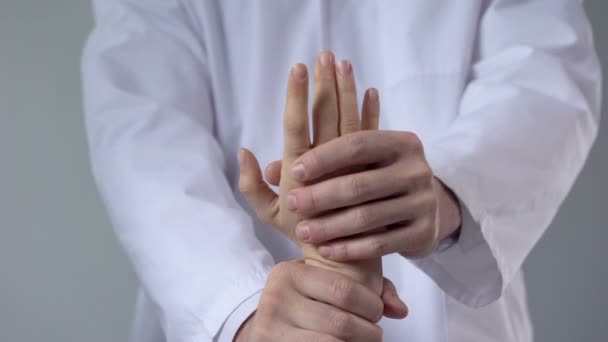 Traumatologista movimentando o punho do paciente, avaliando a gravidade da lesão, close-up — Vídeo de Stock