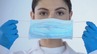 Genç kadın Doktor Ameliyat maskesi, incelenmesi, closeup süre Emanet giyiyor