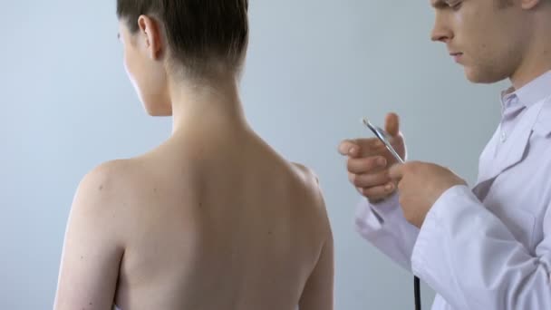 Médecin prenant le stéthoscope et examinant la jeune femme, bilan hospitalier prévu — Video