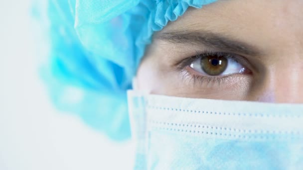 Cirujano profesional en máscara mirando a la cámara, servicios de calidad, primer plano facial — Vídeos de Stock