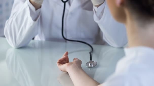 Médico ouvindo pulso de mulher com estetoscópio, consulta na clínica — Vídeo de Stock