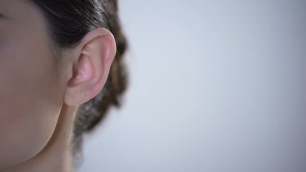 Primer plano de la oreja con audífono, mujer sorda joven ajustándose al medio ambiente — Vídeos de Stock
