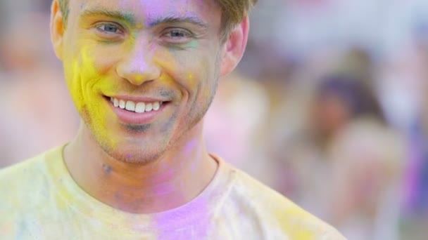 Genç adam başparmak çıkıp, Holi festival kutluyor renk toz gülümseyen — Stok video