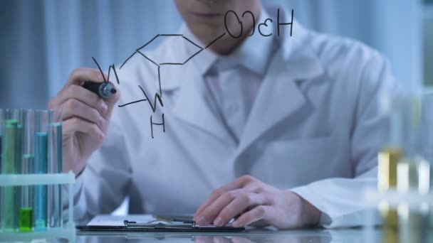 Chemist writing formula on glass and cardboard folder, research in cosmetology — Stock Video