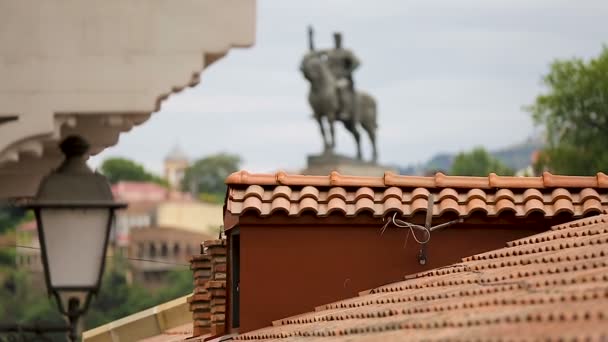 Vista del monumento de Vakhtang Gorgasali sobre el techo de los edificios, figura famosa antigua — Vídeos de Stock