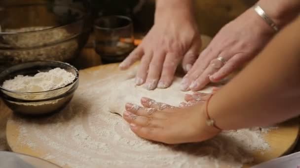 Mother teaching daughter to roll out dough on table at home, hospitality — Stock Video