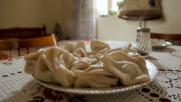 Горячие вкусные домашние хинкали на семейном столе, грузинские кулинарные традиции — стоковое видео
