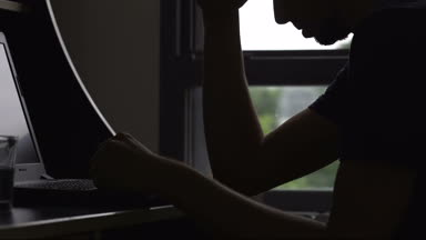 Laptop, işsizlik sorunu, depresyon kıracak yazarak üzgün adam siluet