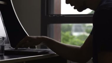 Genç adam yavaş yavaş laptop klavye, yoksul bilgisayar bilgi, online yazarak