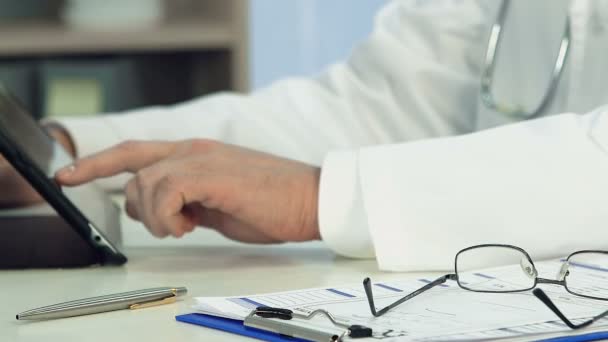 Homme médecin mains vérifier les dossiers médicaux électroniques sur tablette, soins de santé — Video