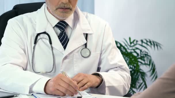 Médico masculino consultando paciente femenino, llenando formulario de registro, medicina — Vídeo de stock