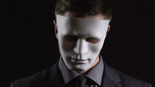 Uomo vestito anonimo in maschera mani pieghevoli su sfondo nero, attività illegale — Video Stock