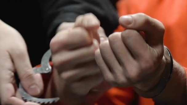 Колонист снимает с человека наручники за встречу с родственниками, выписку из тюрьмы — стоковое видео