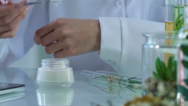 Cosmetologie expert zet crème op haar hand en typen opmerkingen in e-journal — Stockvideo