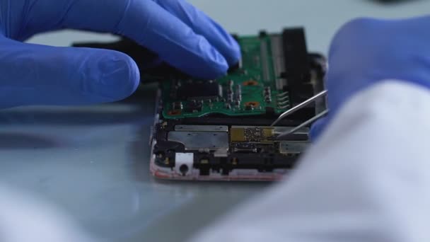 Criminal expert removing microboard from burned mobile phone, investigation — Stock Video